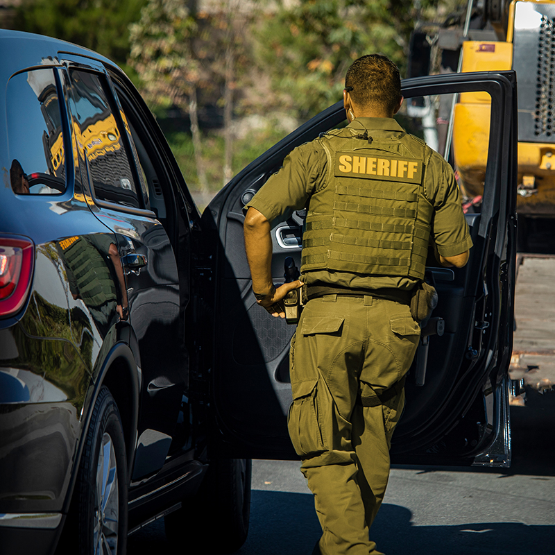 reserves officer standing by sheriff's vehicle